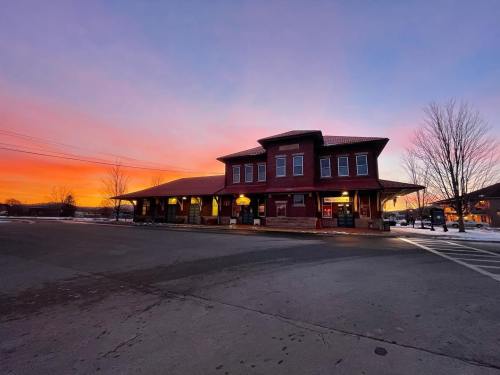 Historic building at sunset, with vibrant colors in the sky and snow on the ground.