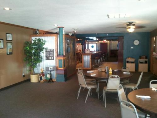 Interior of a casual restaurant with tables, chairs, and a bar area, featuring warm colors and decorative elements.