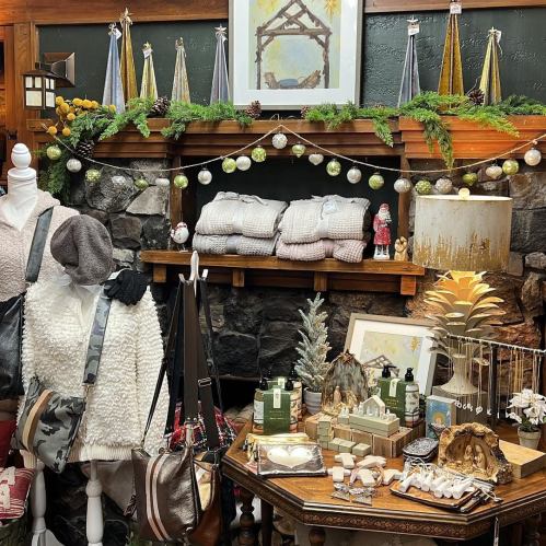 A cozy display of holiday decor, including blankets, ornaments, and festive decorations on a rustic stone shelf.
