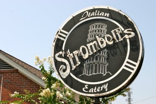 Sign for Stromboli's Italian Eatery featuring a graphic of the Leaning Tower of Pisa against a clear blue sky.