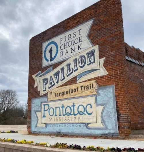 Mural on a brick wall featuring "First Choice Bank Pavilion" and "Pontotoc, Mississippi" at Tanglefoot Trail.