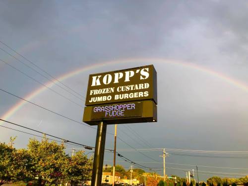 Sign for Kopp's Frozen Custard and Jumbo Burgers with a rainbow in the background and "Grasshopper Fudge" displayed.