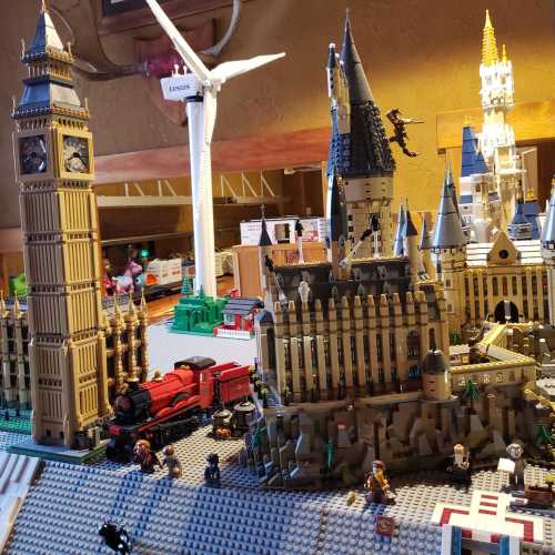 A detailed Lego model featuring Big Ben, a train, and various buildings, set on a textured base.