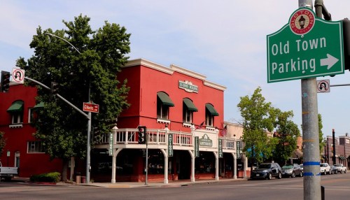 A red building with green awnings, labeled "Littrell's," next to a sign directing to Old Town Parking.