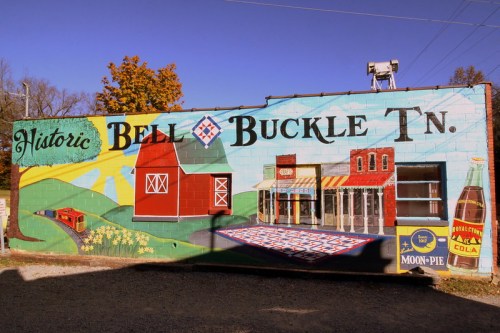 Colorful mural depicting "Historic Bell Buckle, TN" with barns, shops, and local products like Moon Pie and soda.