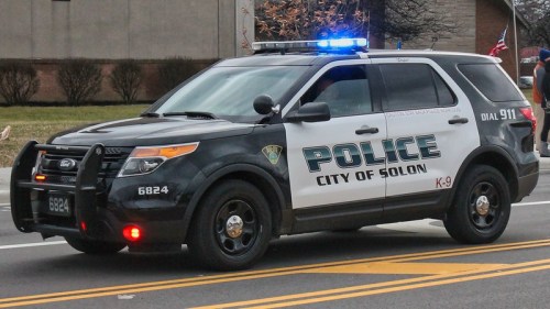 A police SUV with lights on, marked "City of Solon K-9," parked on a street.