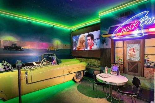 A retro diner scene featuring a yellow convertible, neon lights, and a movie screen showing a classic film.