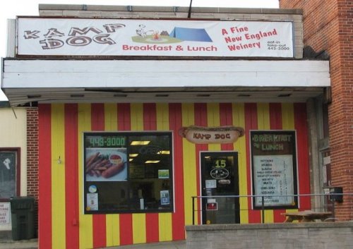Colorful exterior of "Kamp Dog," a breakfast and lunch spot with a sign advertising a New England winery.