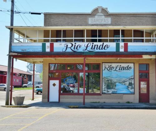 A vintage building with a sign reading "Rio Lindo," featuring colorful murals and a welcoming entrance.