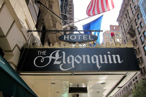Sign for The Algonquin Hotel, featuring ornate lettering, with an American flag and blue flag above.