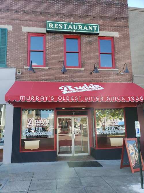 Exterior of a diner with a red awning, sign reading "Murray's Oldest Diner Since 1936," and large glass entrance doors.