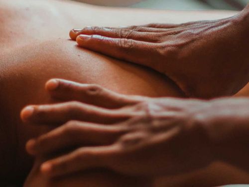 Close-up of hands giving a massage on a person's back, focusing on relaxation and wellness.