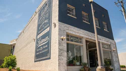 A corner building with a blue and white exterior, featuring decorative signage and large windows.