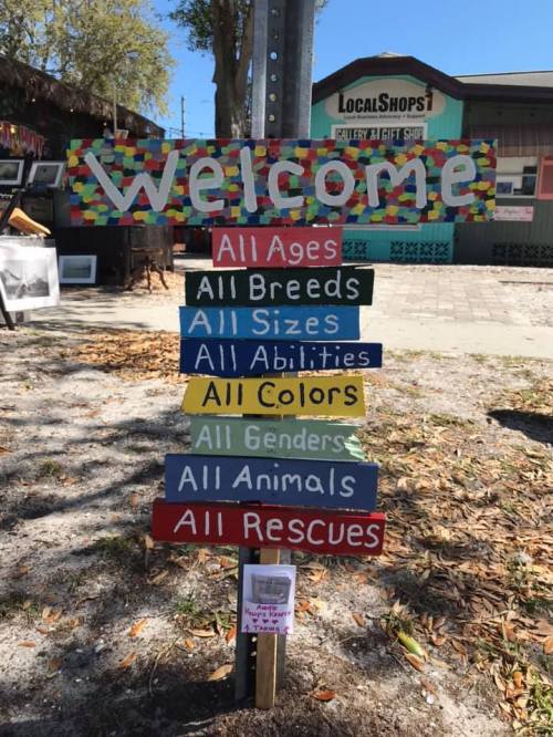 Colorful sign reading "Welcome" with various categories: All Ages, All Breeds, All Abilities, All Colors, All Genders, All Animals, All Rescues.