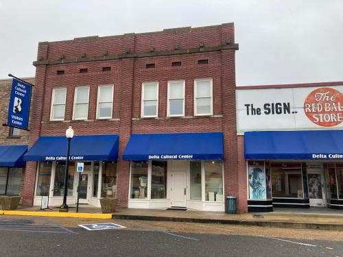 Two brick buildings with blue awnings, featuring the Delta Cultural Center and a store sign for The Red Ball Store.
