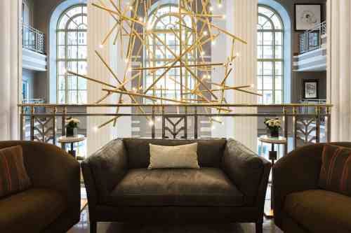 A stylish hotel lobby featuring a modern art installation and comfortable seating.