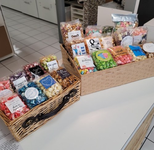 Two wicker baskets filled with colorful popcorn bags and treats, displayed on a counter.