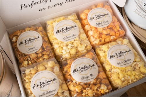 A box of assorted popcorn flavors, including vanilla buttered, cheddar mix, and white cheddar, neatly packaged.