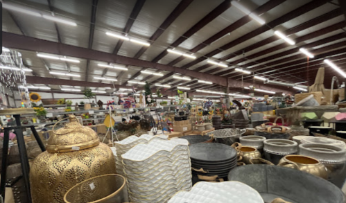 A spacious store filled with various decorative items, including metal containers, planters, and home decor.