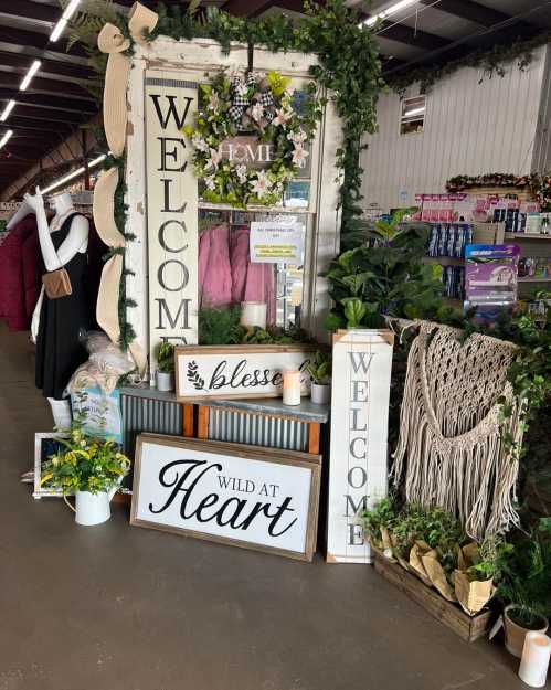 A cozy shop display featuring welcome signs, greenery, and decorative items, creating a warm, inviting atmosphere.