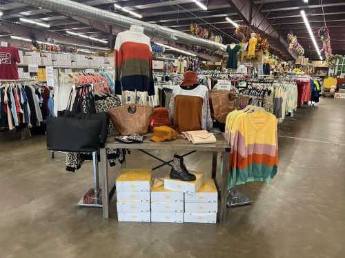 A display of colorful clothing and accessories on a table in a spacious retail store.