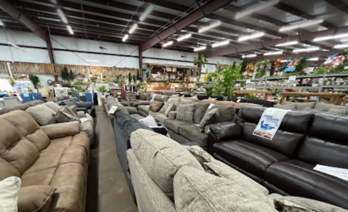 A spacious furniture store showcasing various sofas in different colors and styles, arranged in rows.