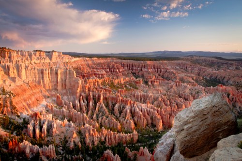 A stunning view of Bryce Canyon's colorful rock formations at sunset, with layered cliffs and a dramatic sky.