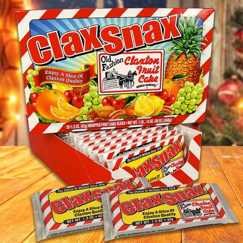 A box of Claxton Fruit Cake slices, featuring colorful fruit graphics and red and white striped packaging.