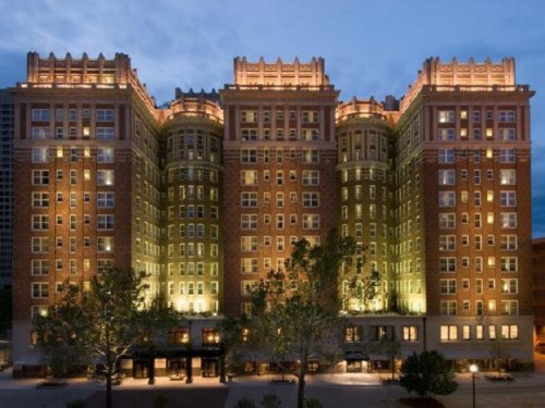 Historic brick hotel illuminated at dusk, featuring ornate architecture and multiple stories.
