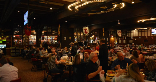 A bustling restaurant filled with diners at tables, decorated with banners and warm lighting.
