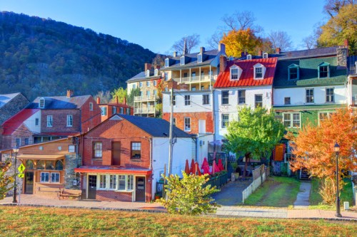 Charming historic buildings with colorful facades and autumn foliage, set against a backdrop of rolling hills.