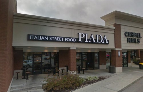 Exterior of a restaurant named "Piada," featuring a sign that reads "Italian Street Food," next to a nail salon.