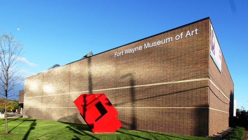 Exterior of the Fort Wayne Museum of Art, featuring a large red sculpture in front of a brick building.
