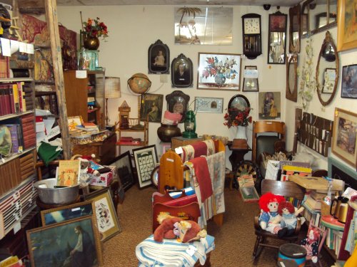 A cozy antique shop filled with various vintage items, including furniture, artwork, and decorative pieces.
