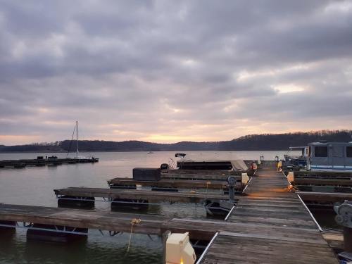 A serene lake view at sunset, with wooden docks extending into the water and cloudy skies above.