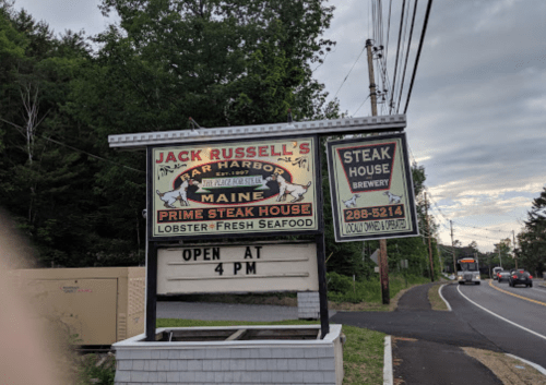 Sign for Jack Russell's Bar Harbor, Maine, featuring steak, lobster, and seafood. Open at 4 PM.