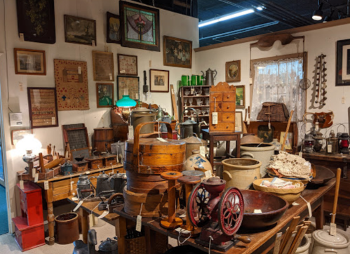 A cozy antique shop filled with vintage items, including furniture, lamps, and various collectibles on display.