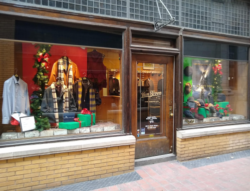 Storefront display featuring festive clothing and decorations, with holiday-themed items in the windows.