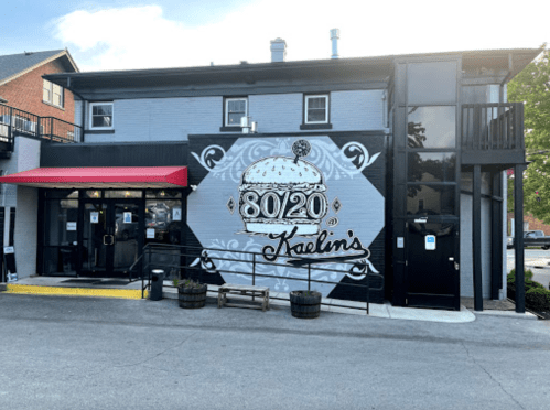 Exterior of Kaelin's restaurant featuring a large mural with "8020" and a burger design, along with a red awning.