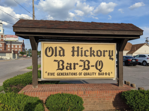 Sign for Old Hickory Bar-B-Q, featuring the text "Five Generations of Quality Bar-B-Q" against a blue sky backdrop.