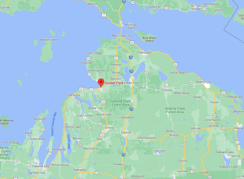 Map showing the location of Sunset Park in Michigan, near the coast and surrounded by various towns and forests.
