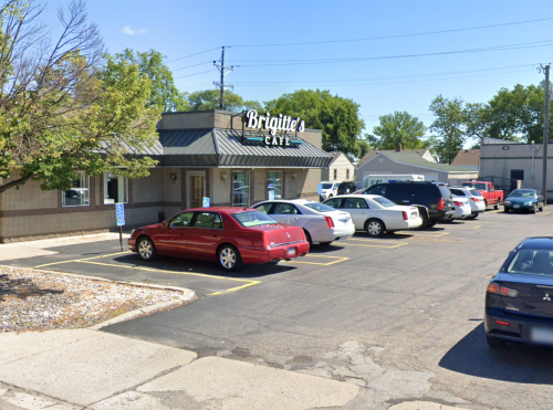 Exterior of Brigitte's Café with a parking lot filled with cars on a sunny day.