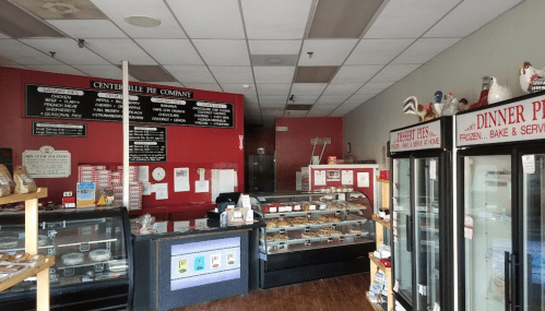 Interior of a pie shop with display cases, a counter, and a menu board on the wall. Warm, inviting atmosphere.