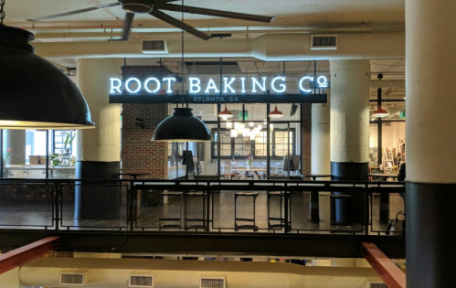 A view of Root Baking Co. in Atlanta, featuring a modern interior with large windows and industrial decor.