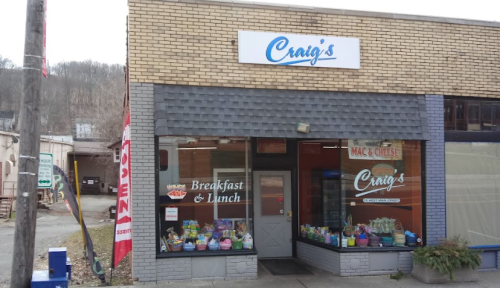 A storefront with a sign reading "Craig's" and "Breakfast & Lunch," featuring colorful displays in the windows.