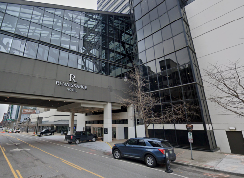 Exterior view of the Renaissance Hotel, featuring modern glass architecture and a parking area.