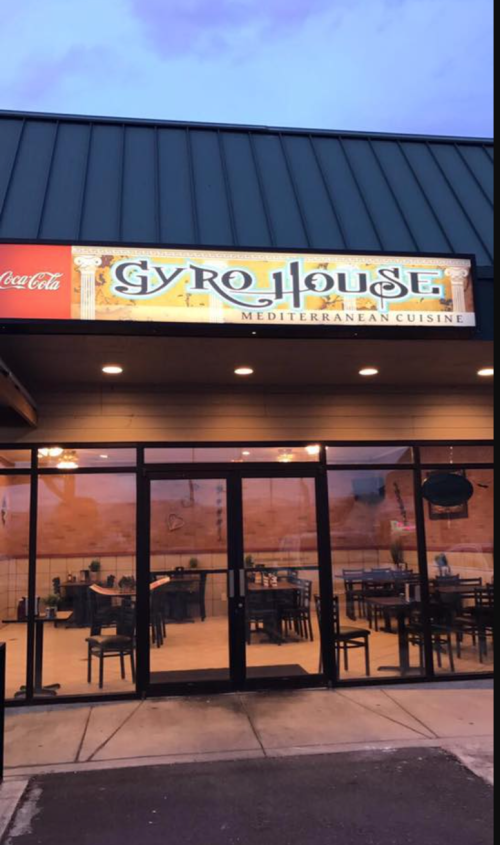 Exterior of Gyro House restaurant, featuring a sign for Mediterranean cuisine and a view of empty indoor seating.