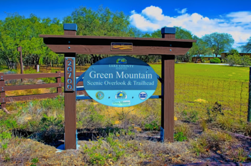 Sign for Green Mountain Scenic Overlook & Trailhead, with a clear blue sky and green landscape in the background.