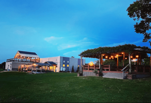 A scenic view of a venue with a gazebo and string lights, set against a twilight sky.