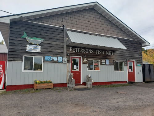 A rustic fish market building with a sign reading "Peterson's Fish Mkt" and a gravel entrance.